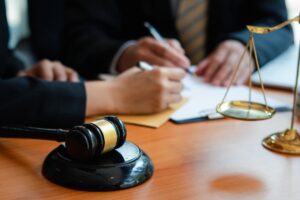 lawyers discussing contract papers with brass scale on wooden desk in office. Law, legal services, advice, Justice concept