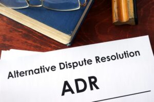 Documents titled "Alternative Dispute Resolution (ADR)" placed on a table.