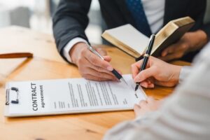 A lawyer advising a client as they sign a document, emphasizing the legal consultation and agreement process.






