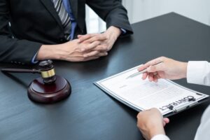 A professional male lawyer or counselor discussing a legal case negotiation with a client, reviewing contract documents in the office, with law and justice symbols.